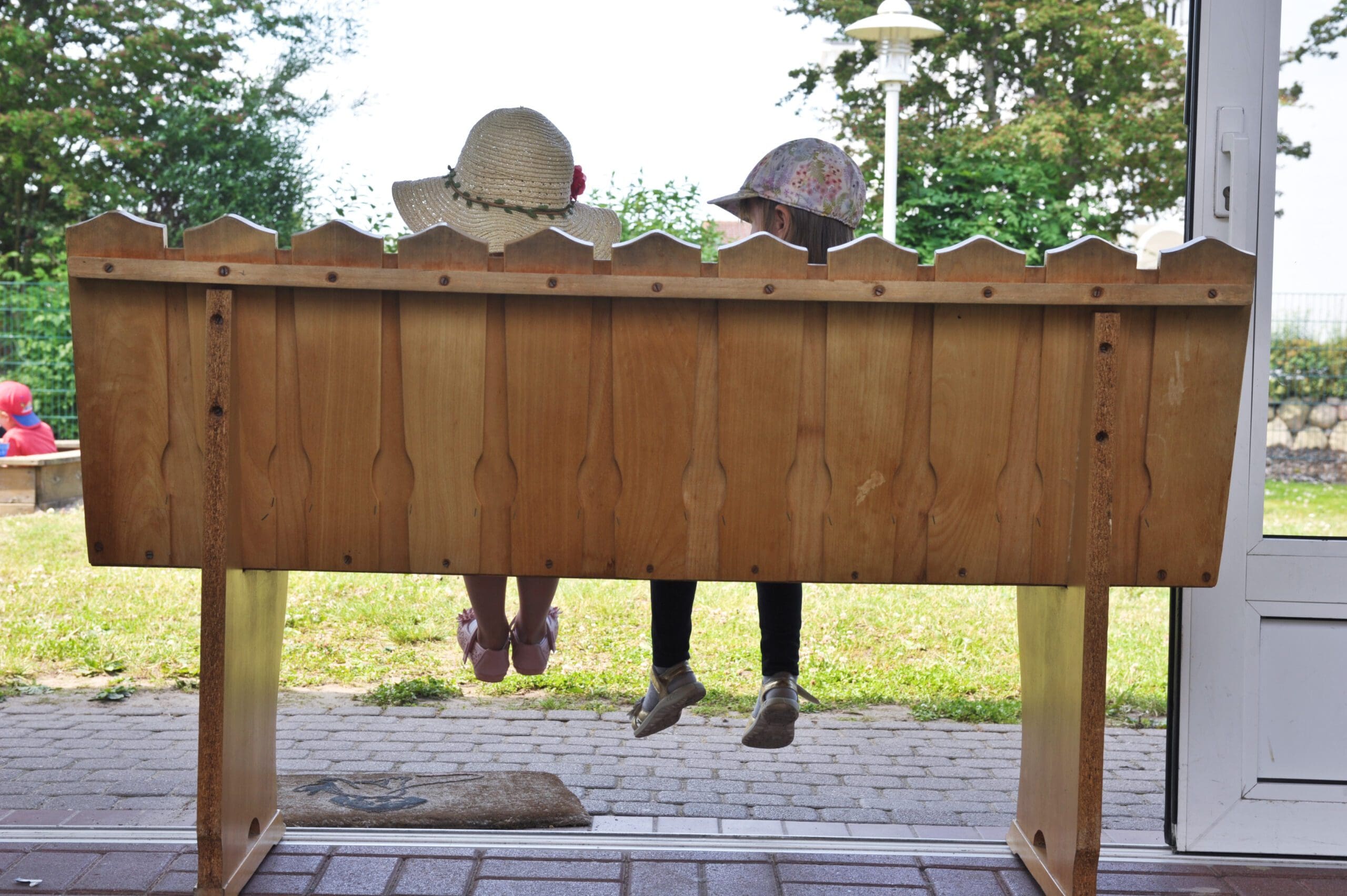 Zwei Mädchen sitzen zusammen auf einer Bank