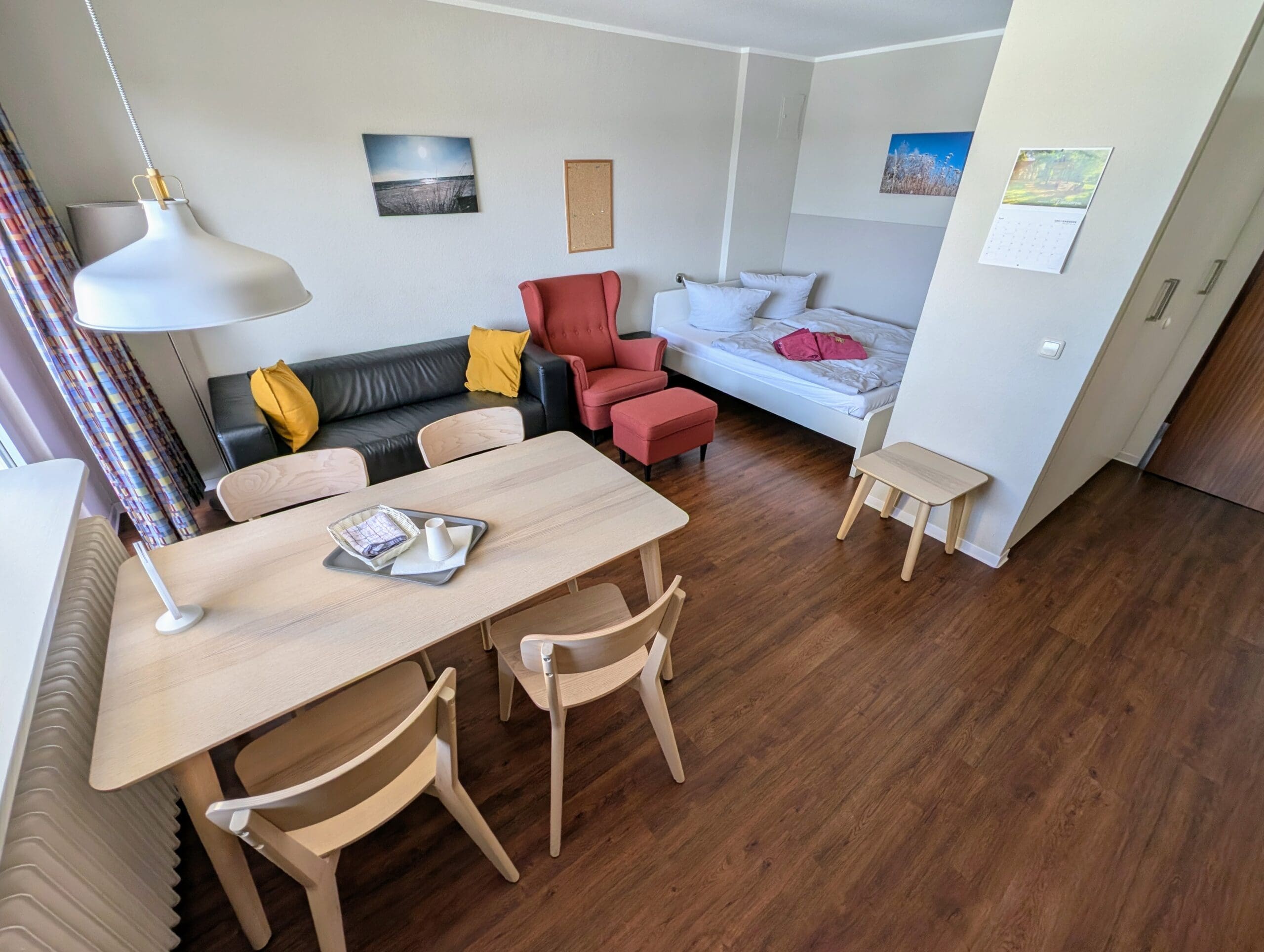 Wohnzimmer mit Sofa, Sessel und Holztisch