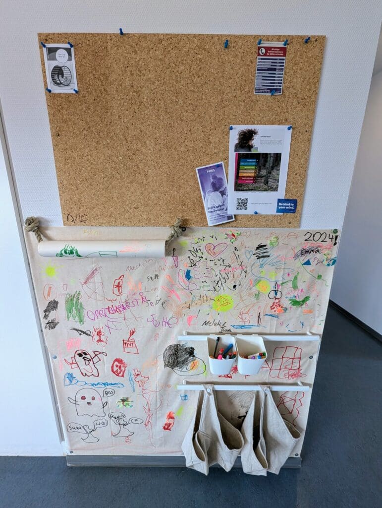 Wandtafel mit Kinderbildern und Nachrichten