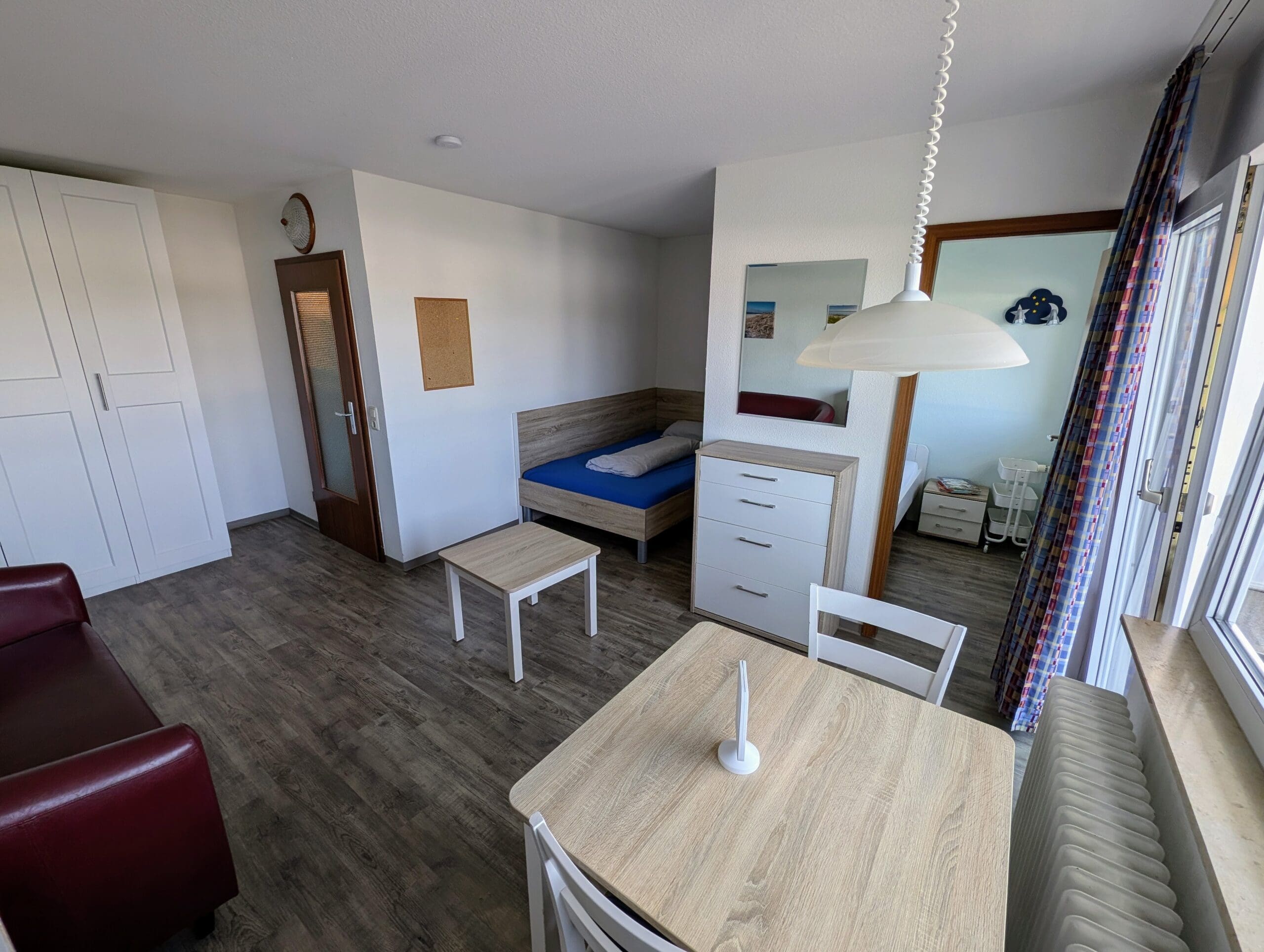 Appartement mit Sofa, Tisch und Küchenzeile
