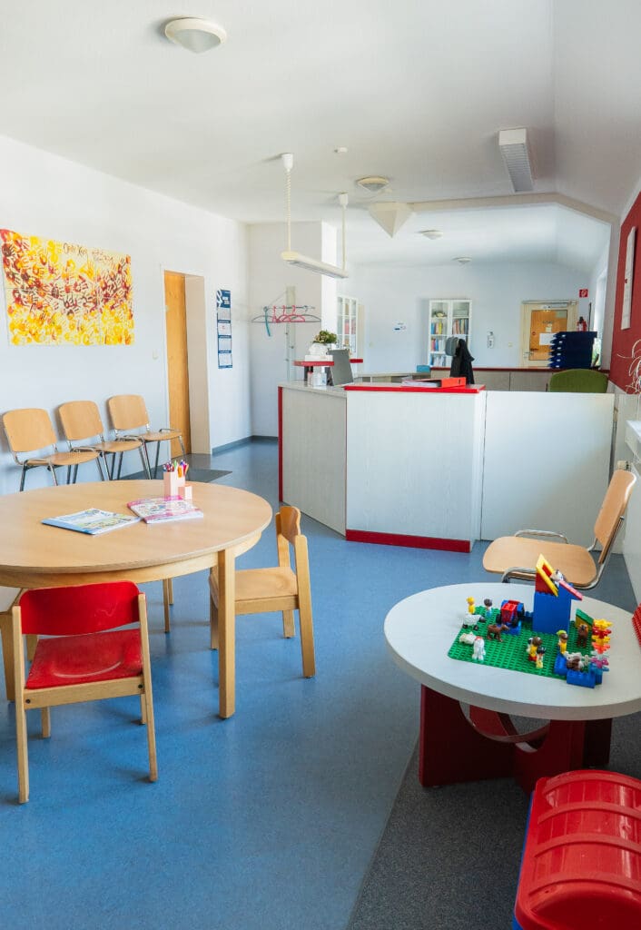 Wartebereich mit Kindertisch und Spielmaterial