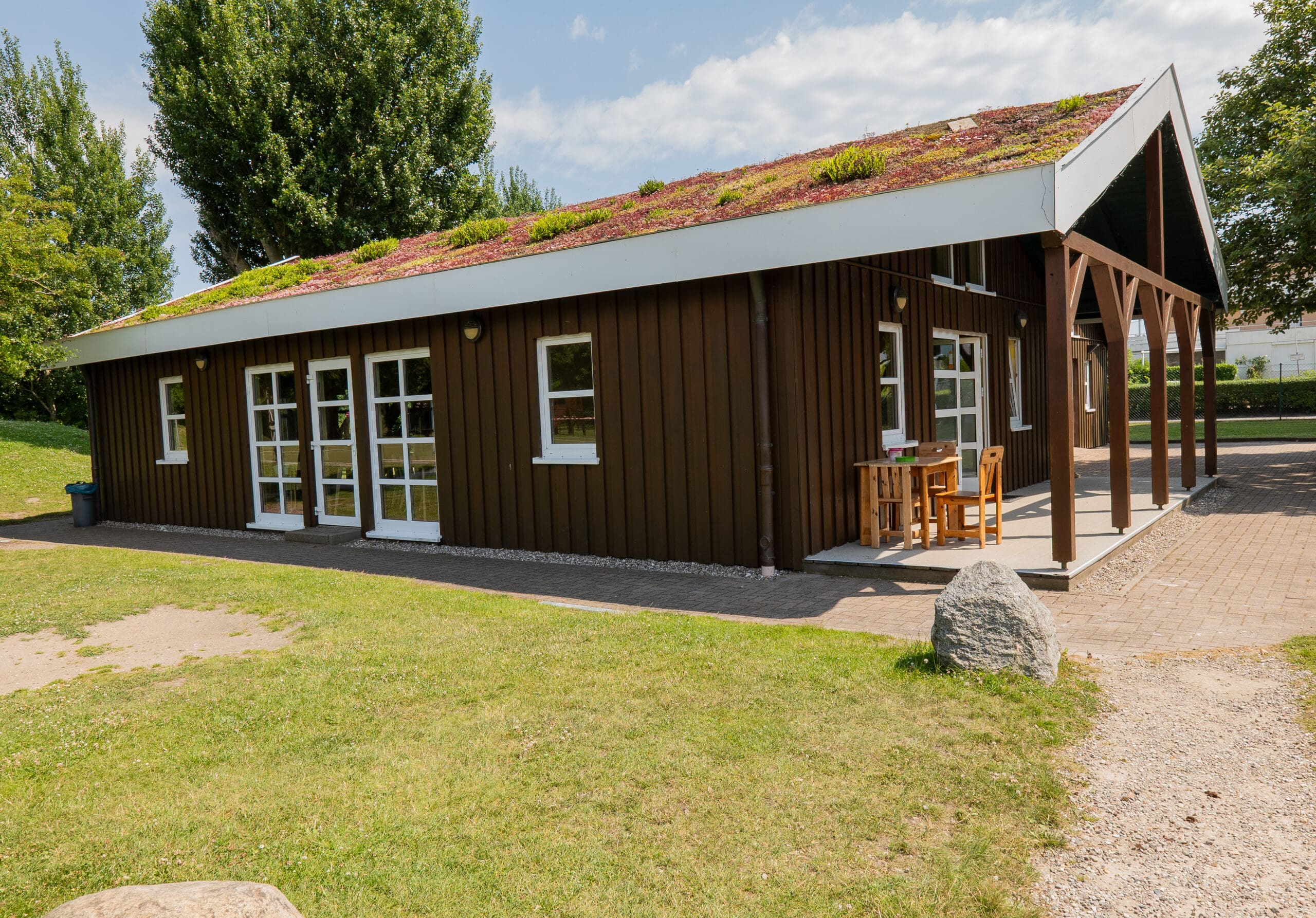 Clubhaus mit Holzbänken und Vordach