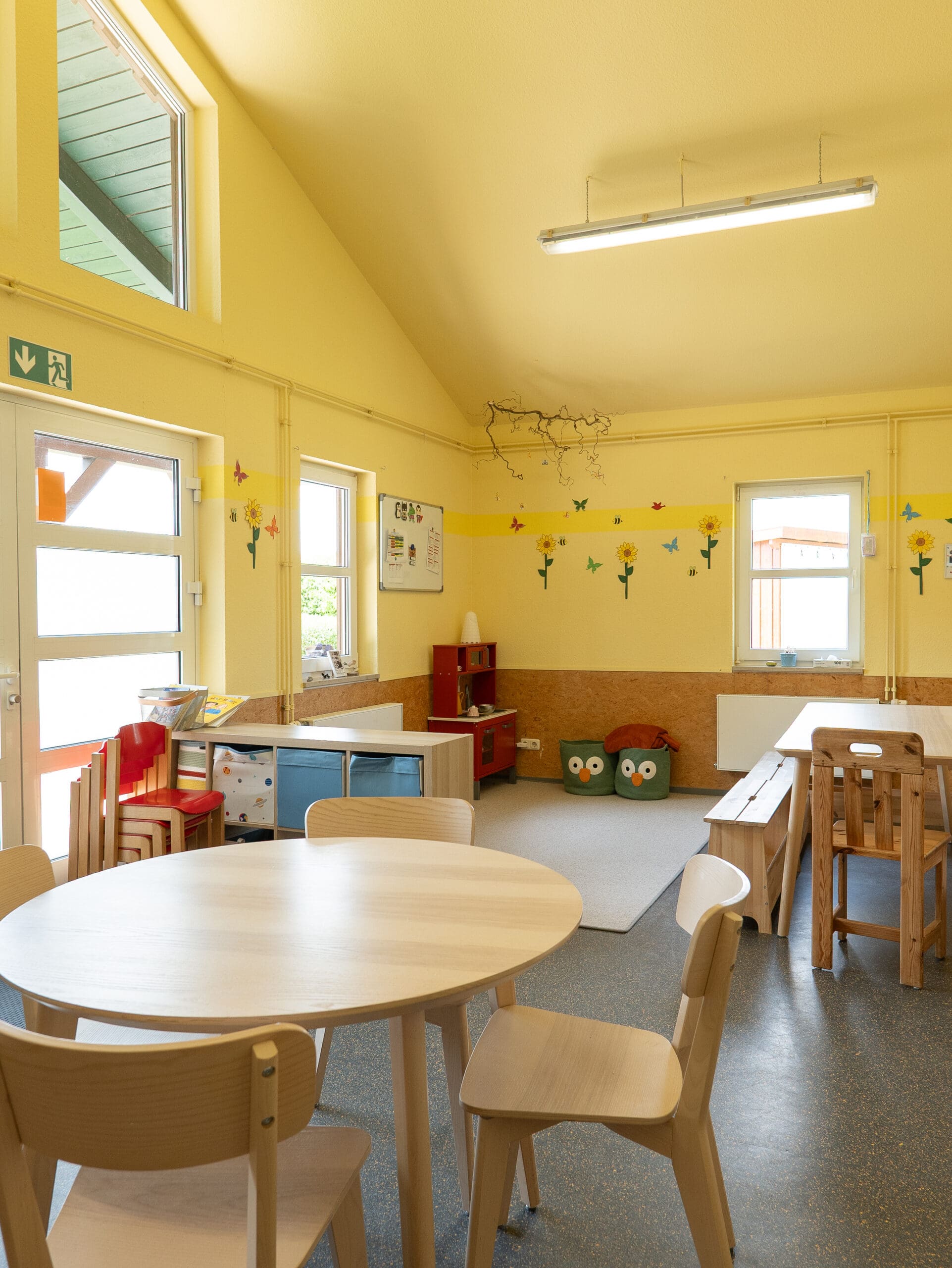 Gruppenraum mit Tischen und Spielzeug