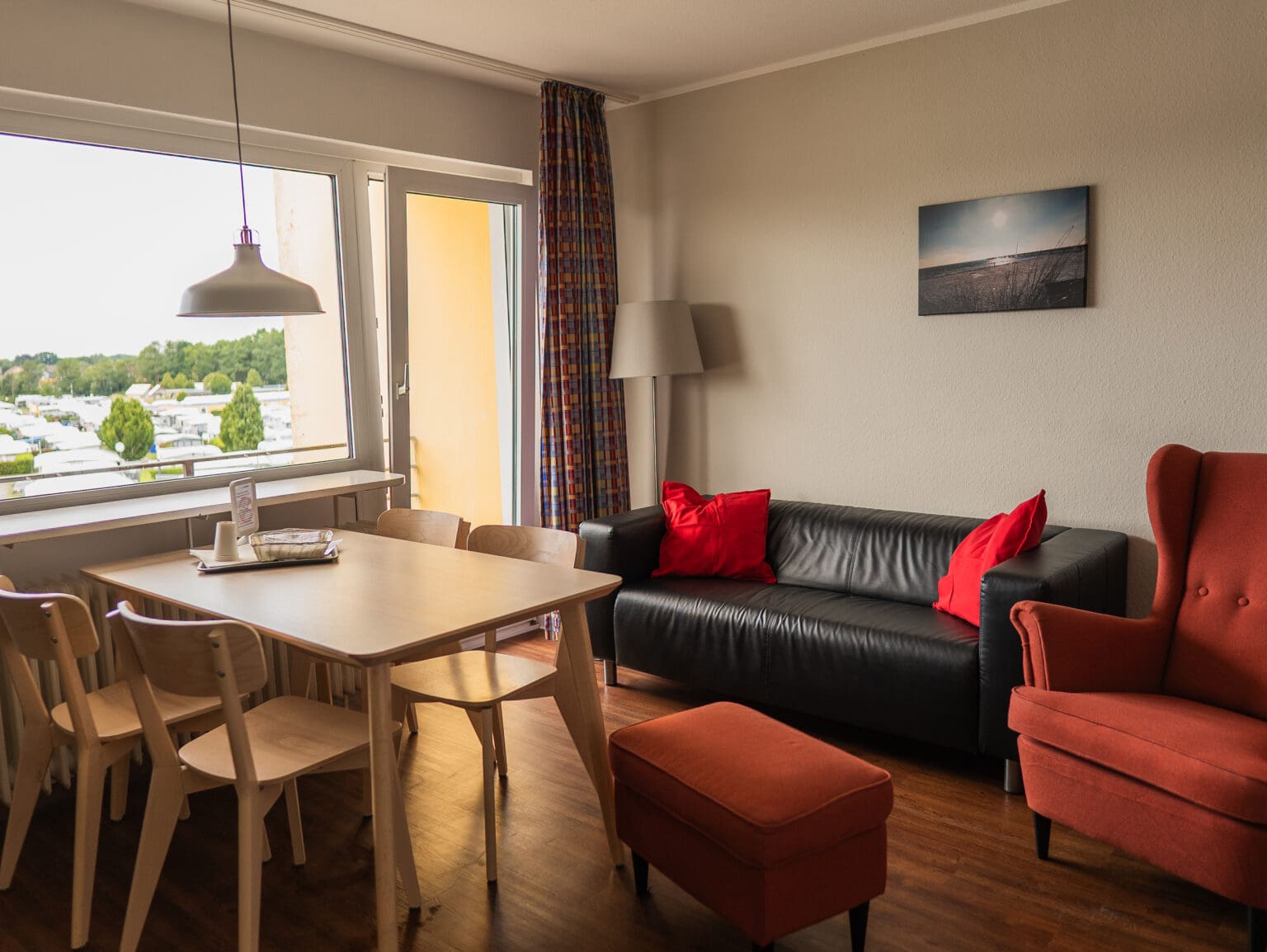 Wohnzimmer mit Sofa, Esstisch und Fenster