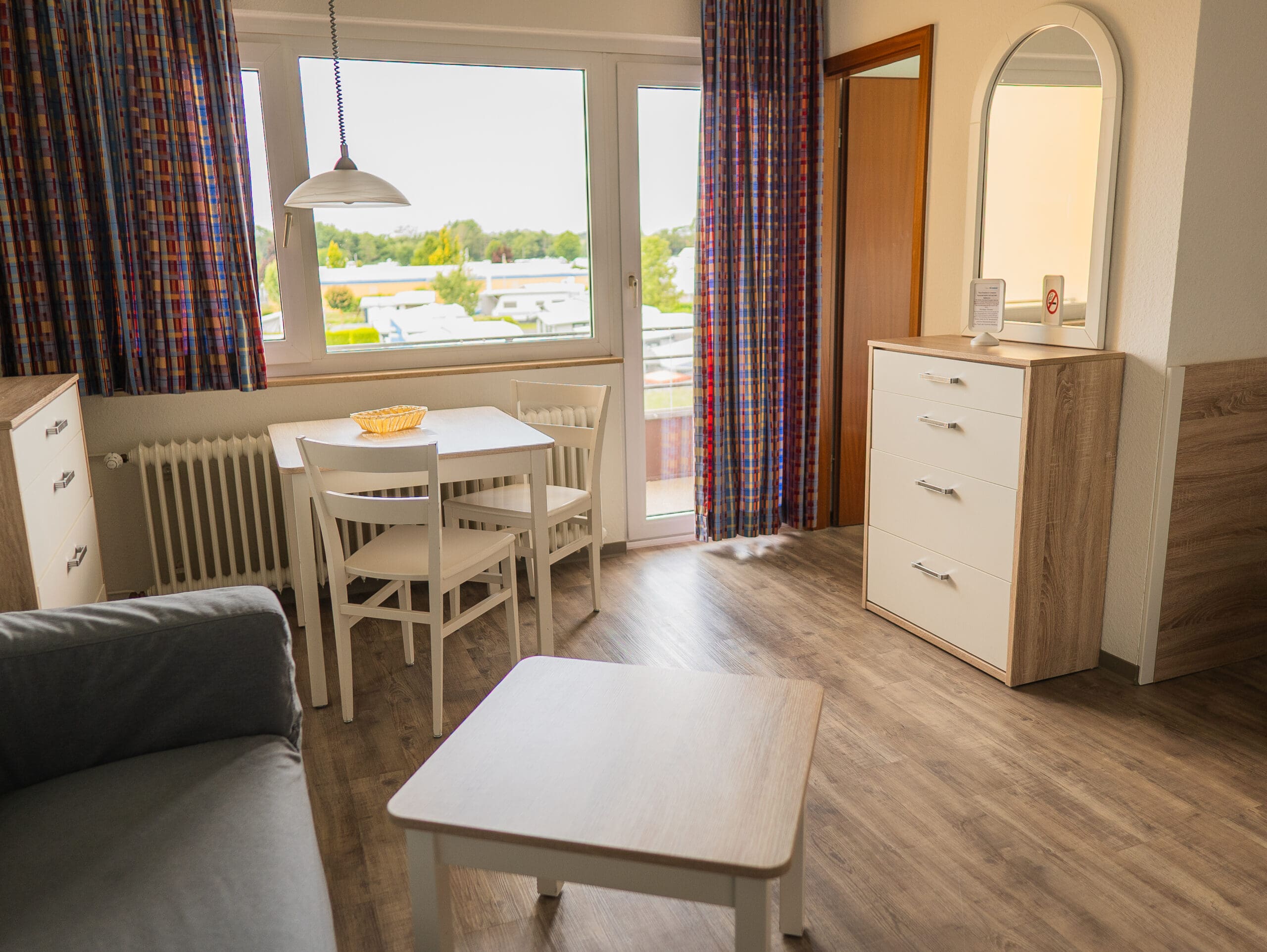 Appartement mit Esstisch, Vorhängen und Kommode