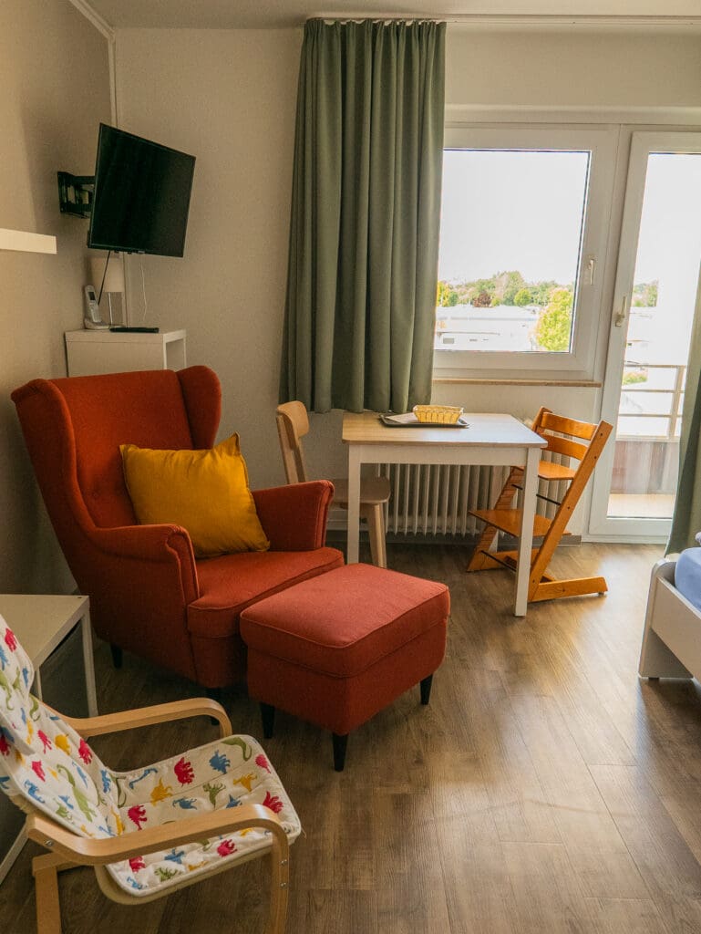 Wohnbereich mit Fernseher, Sessel und Babyhochstuhl